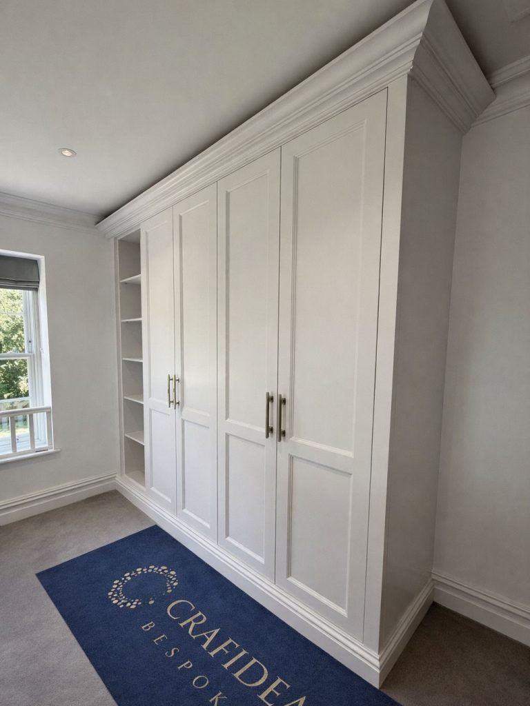 White built-in cabinetry with two large doors and a small shelving unit beside it.